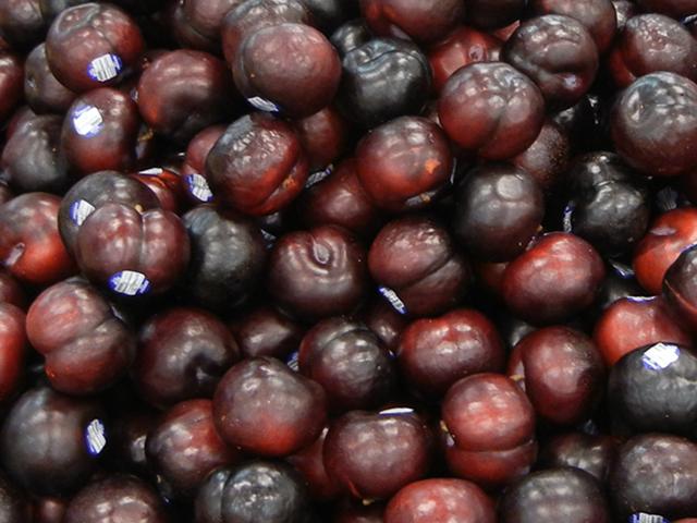 Black plums, a rich dark purple and red color, with shiny skin
