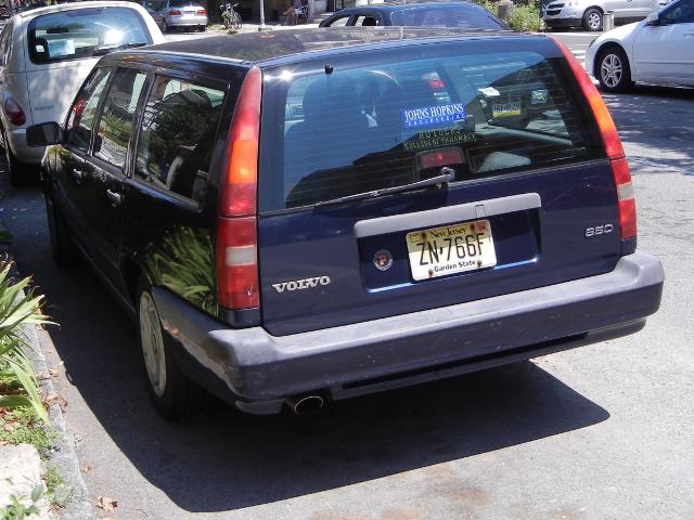 A navy blue Volvo station wagon 850, with New Jersey plates, parked on a city street
