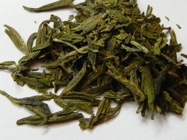 Flat green tea leaves, with a rich golden-yellowish green color