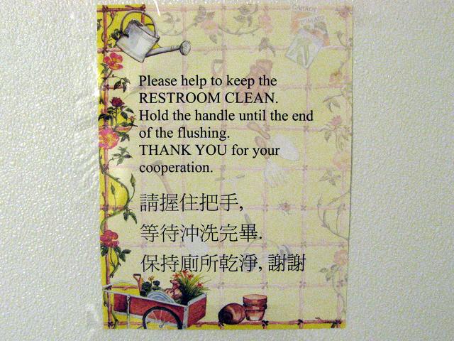 An amusing sign on a Chinese restroom wall, with both English writing and Chinese characters
