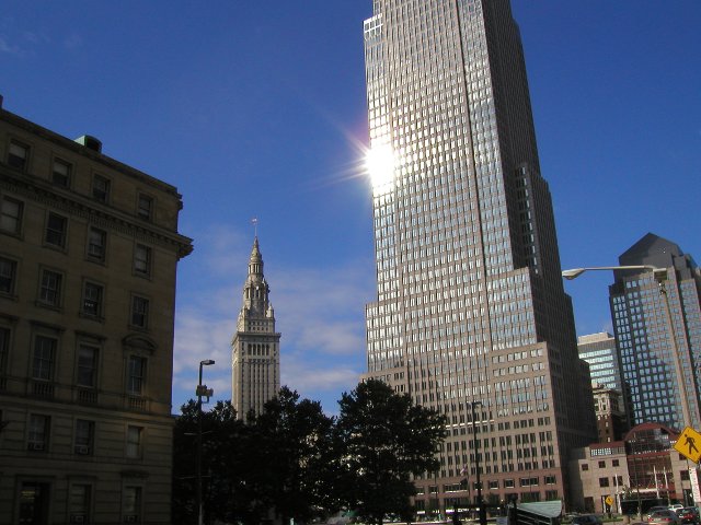 Cleveland's key tower, a modern, shiny skyscraper, and the older, classic terminal tower in the background, rising from behind trees