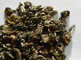 Loose-leaf green tea with tightly rolled shapes, somewhat spindly-looking, and golden and silvery green in color