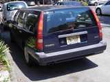 A navy blue Volvo station wagon 850, with New Jersey plates, parked on a city street