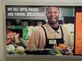An advertisement showing a supermarket and employee, saying: WE SELL SEPTA PASSES AND TOKENS.  DELICIOUS!  Buy your passes or tokens at Shoprite.