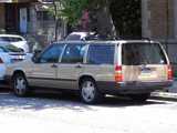 A beige Volvo stationwagon 940 turbo, in good condition, parked on a city street