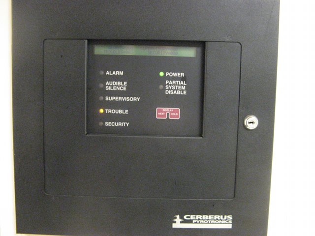 A security system with many indicator lights, with the trouble indicator light illuminated