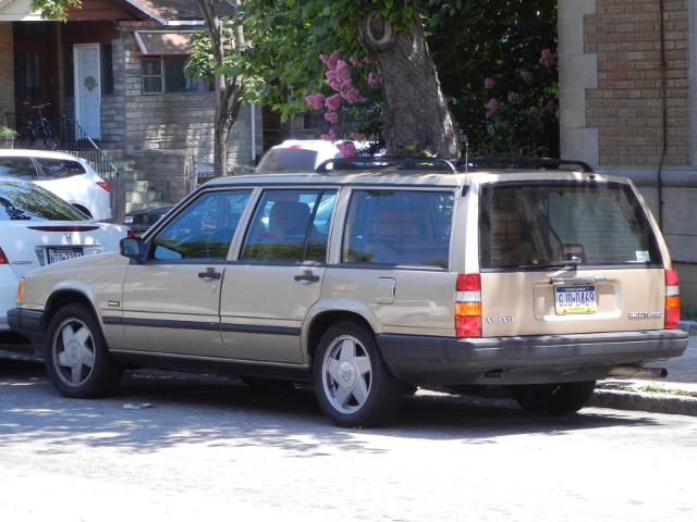 A beige Volvo stationwagon 940 turbo in good condition parked on a city 