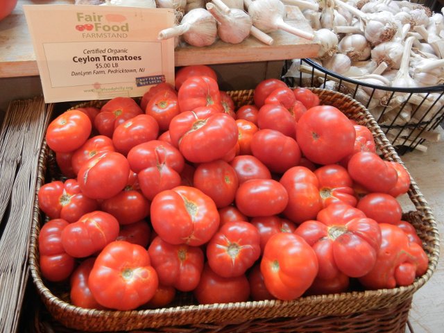 A basket of ceylon tomatoes, a bright red, round but somewhat flat variety of tomato