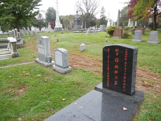 A black tombstone with Chinese characters, in a mostly English cemetery