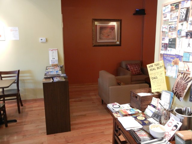A community bulletin board on the right, with a cozy seating area with sofas behind