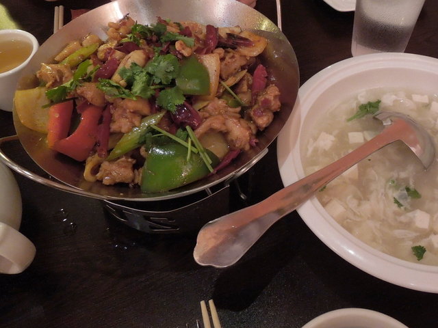 Sichuan dry pot, a colorful dish in a metal bowl, with lots of hot peppers, and a white bowl of seafood tofu soup