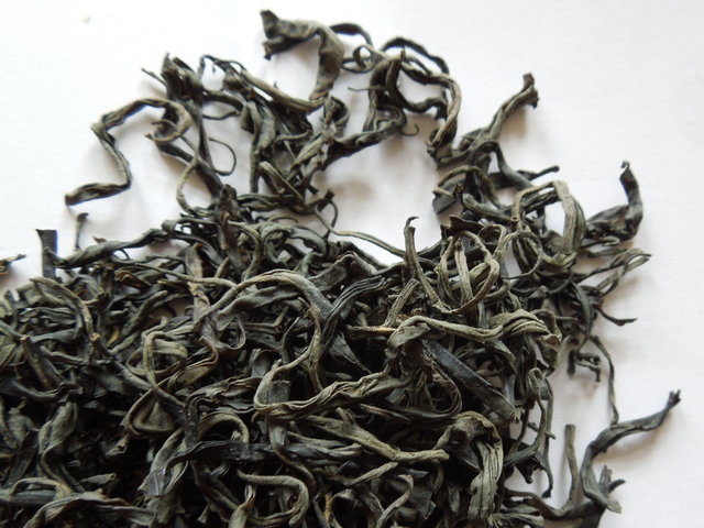 Loose-leaf green tea showing whole, gray-green leaves with a long, twisted shape