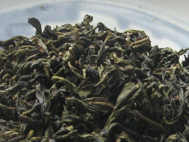 Long, slightly curled tea leaves, with a dark blue-green color