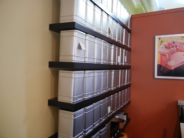 Square metal tea tins on a shelf, in a tea shop