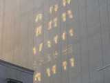 Closeup of patterns that look like alien hieroglyphics, projected onto the blank wall of a building
