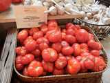 A basket of ceylon tomatoes, a bright red, round but somewhat flat variety of tomato