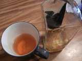 A mostly empty mug of tea, next to a bottle of Wild Turkey American Honey bourbon