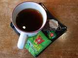 Mug of black tea, with Wissotzky Tea Classic tea bag and wrapper on plate next to mug