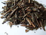 Closeup of dark brown roasted tea leaves and twigs