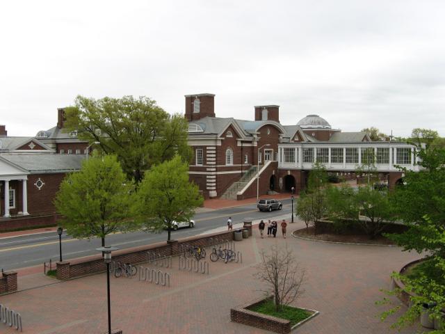 University of Delaware Campus, a terrace with red brick, and buildings in an old style with brick and white trim, and slate roofs, and an overpass over a street, with trees leafing out in the spring