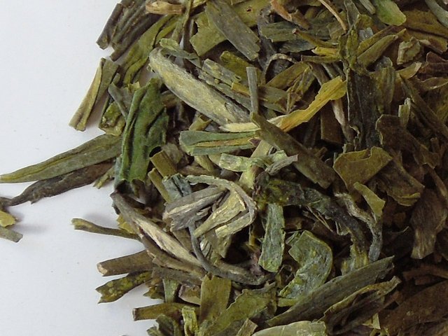Loose-leaf dragonwell green tea, with long, flat leaves, this one showing blunt ends